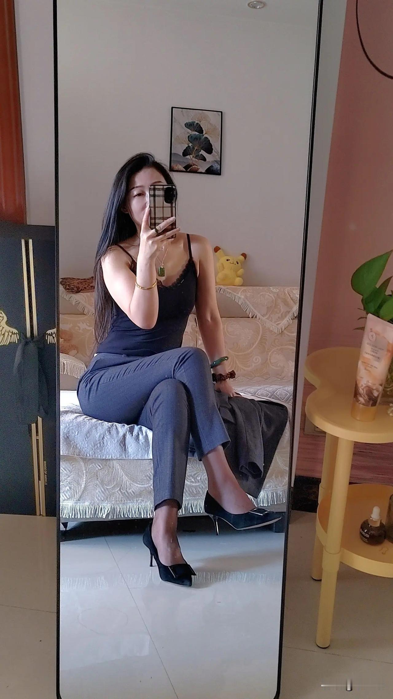 一个女孩穿着西装，坐在床上自拍。
