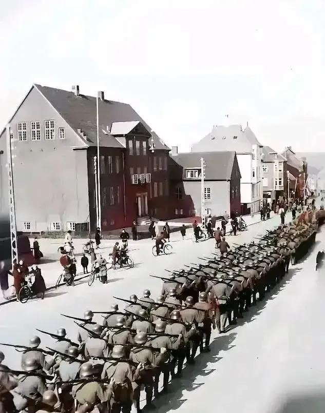 1940年入侵丹麦的德军排着整齐的队伍进城，而当地老百姓一个个相安无事，好像什么