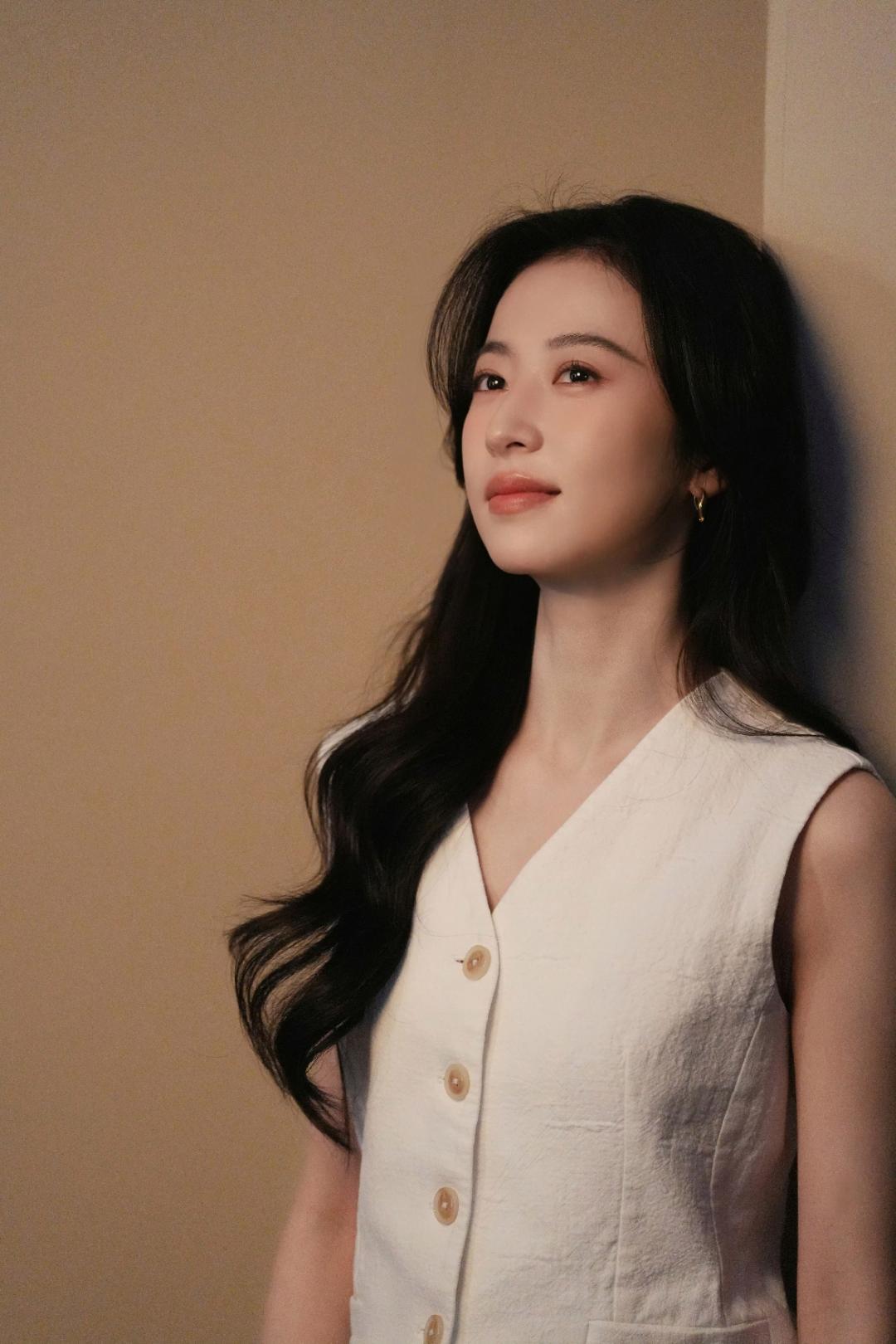 当柔暖杏光漫过肩头，当松卷发丝拂过眉眼，周雨彤以两组极简质感大片，将“松弛感”与