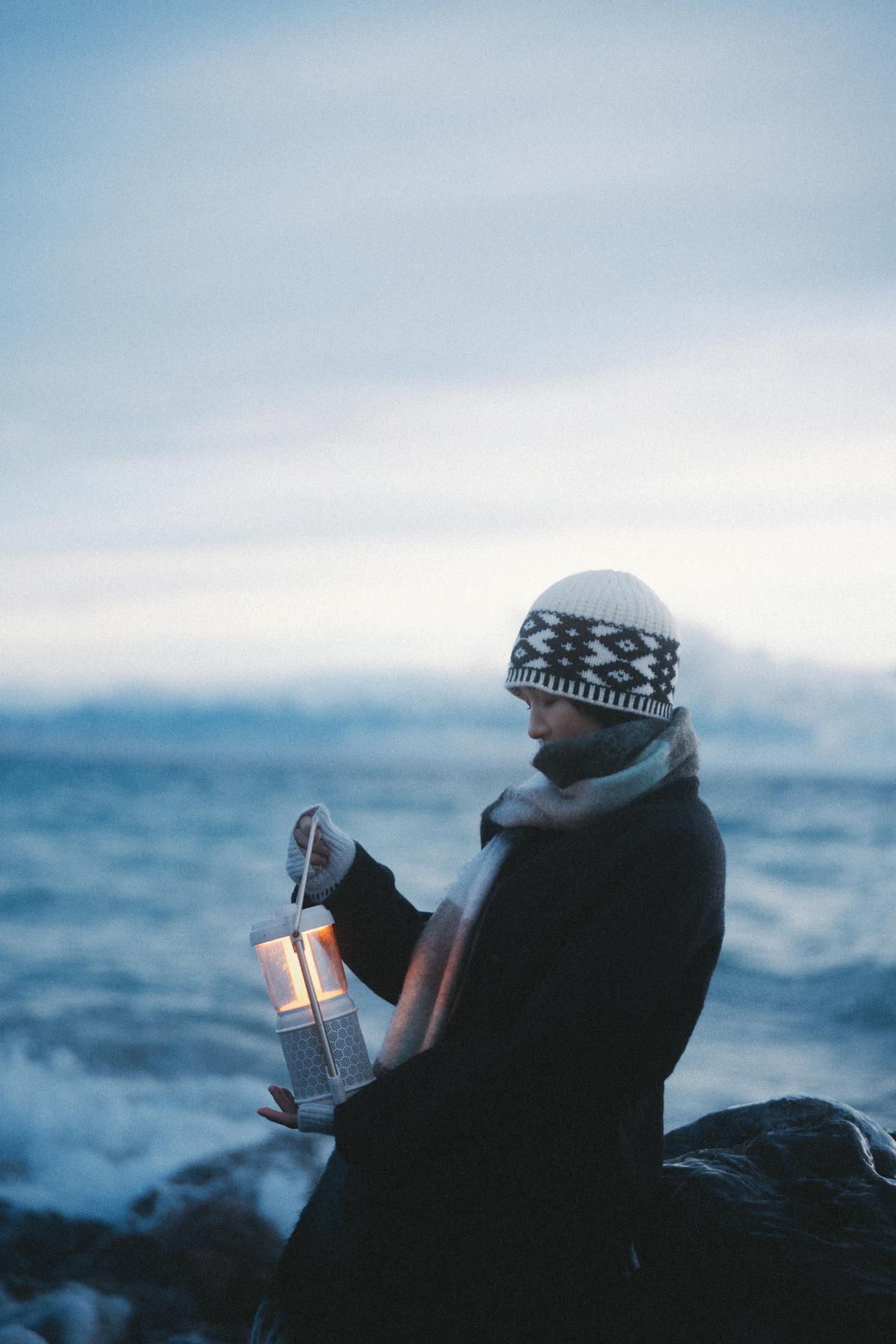 道具是海边少女摄影中传递情绪的关键，这组照片里的复古灯笼，既是视觉元素，也是情绪