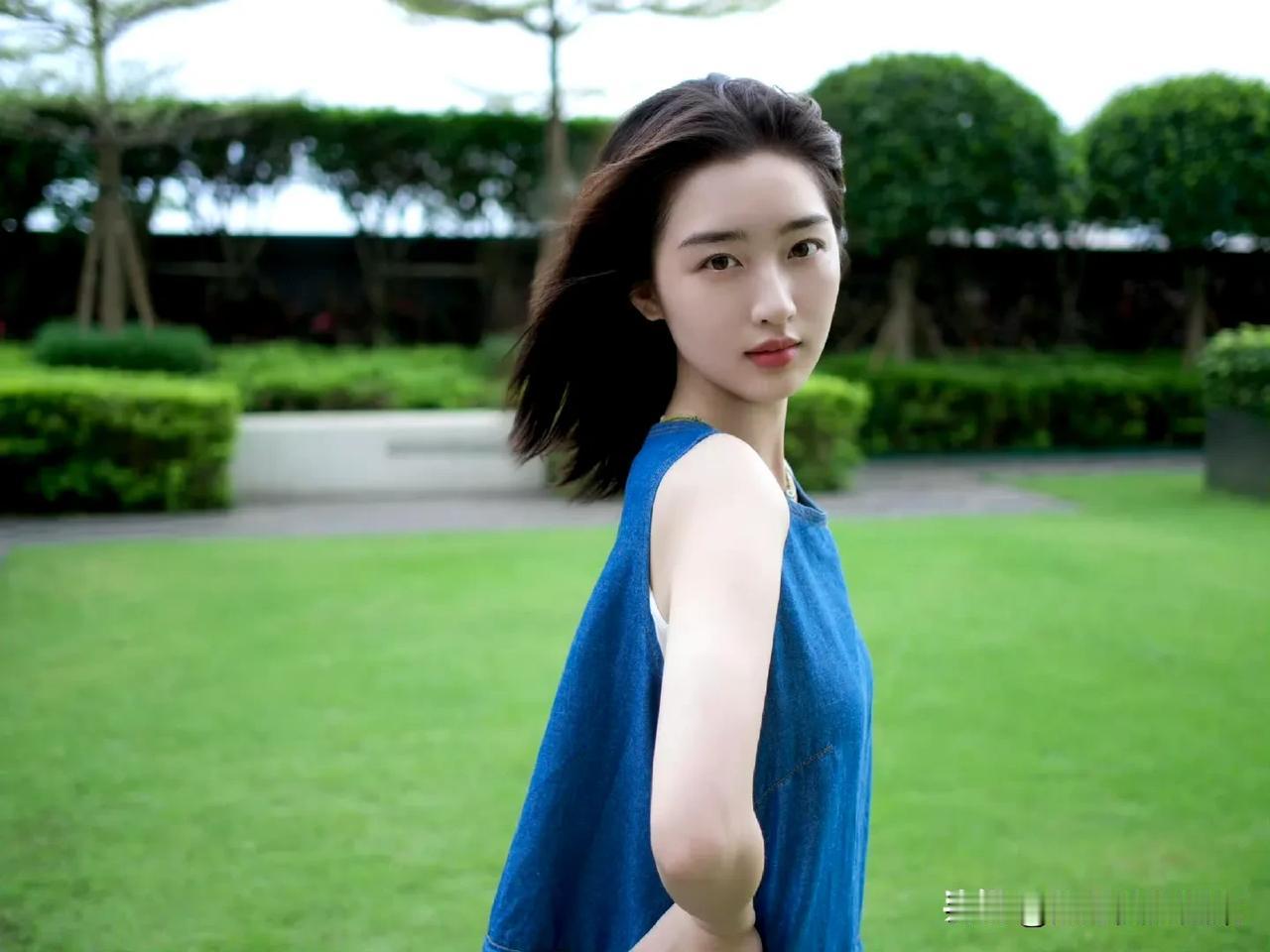 邓恩熙的写真简直把少女模样诠释到极致。在绿湖边的写真里，她一袭白裙搭配玳瑁眼镜