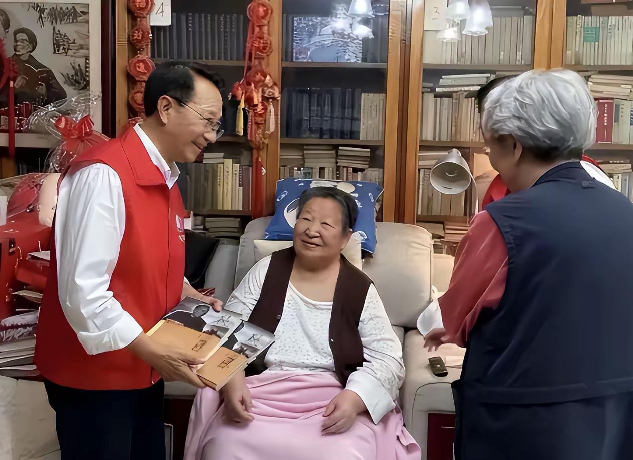 86岁的李讷，坐在沙发上，头发花白，但眼神清亮，坐得端端正正，精气神一点不输年轻