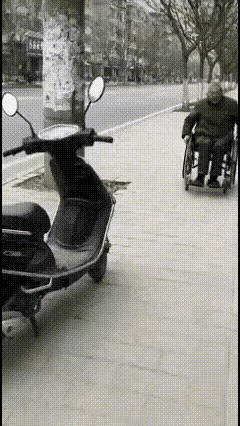 林子大了什么鸟都有宽宽的人行道上一位70多岁的残疾老人双手推着轮椅缓缓