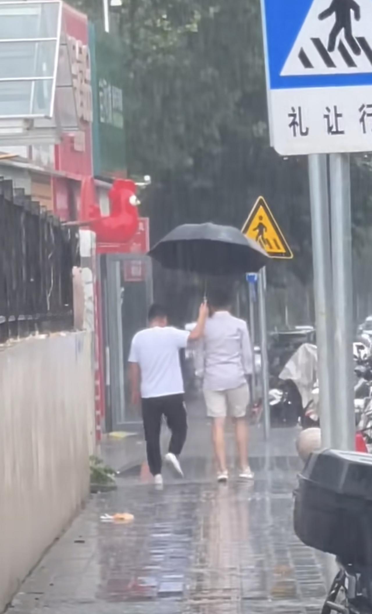 汪小菲吃饭突遇北京大雨，司机给他撑伞送他上车，半个身子都在外面，汪小菲双手插兜向