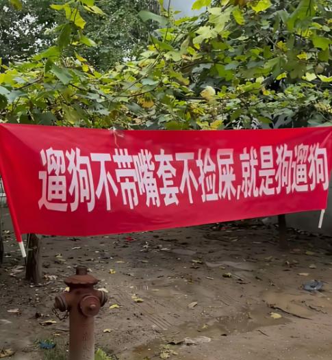 物业挂出了这横幅,小区养狗人士都不服,说这样太侮辱人了,大家帮看看,挂这样的横幅