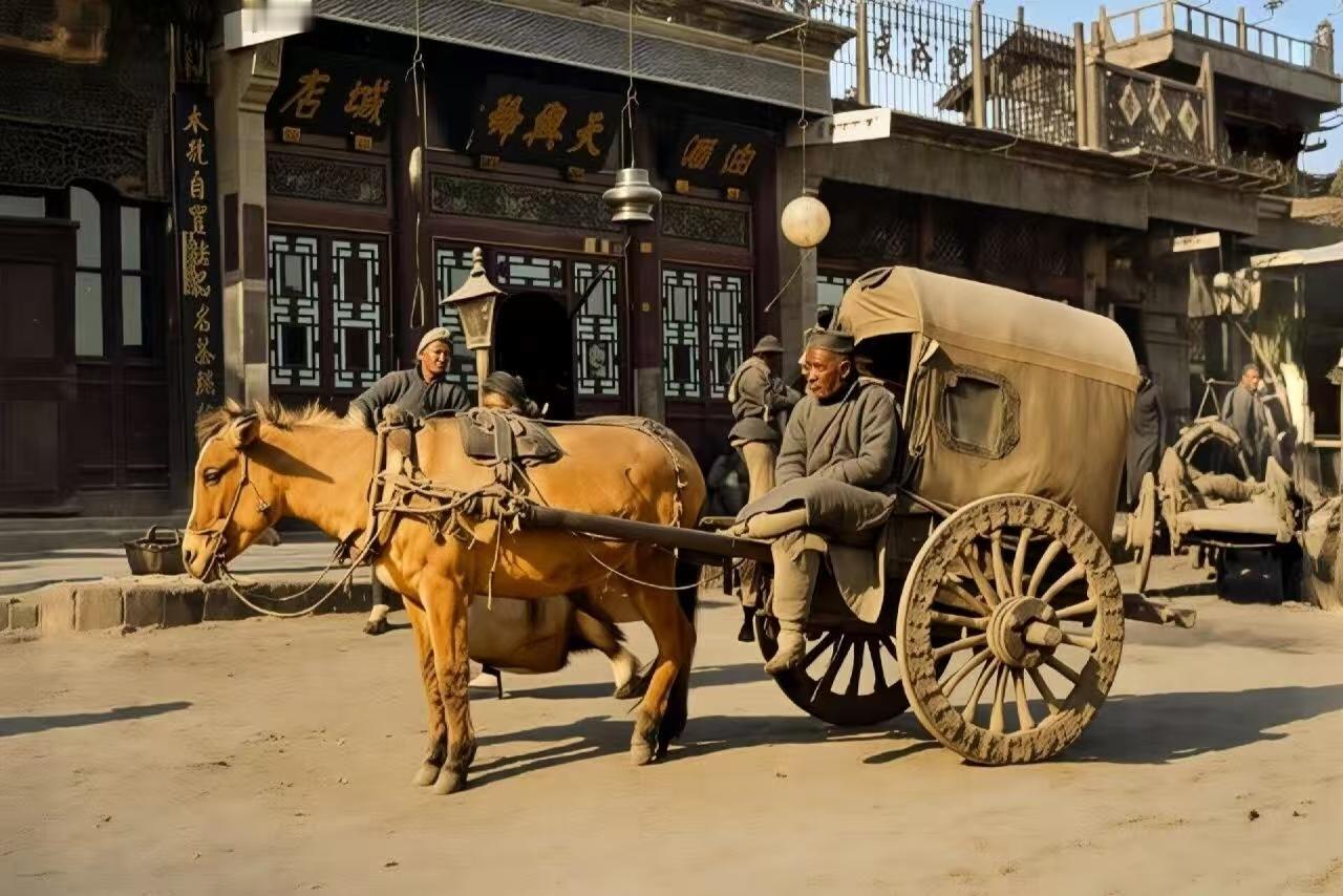 这是清代末年的一张旧照：一位年老的车夫驾驶着一辆两轮马车，行走在城市的街道上。可
