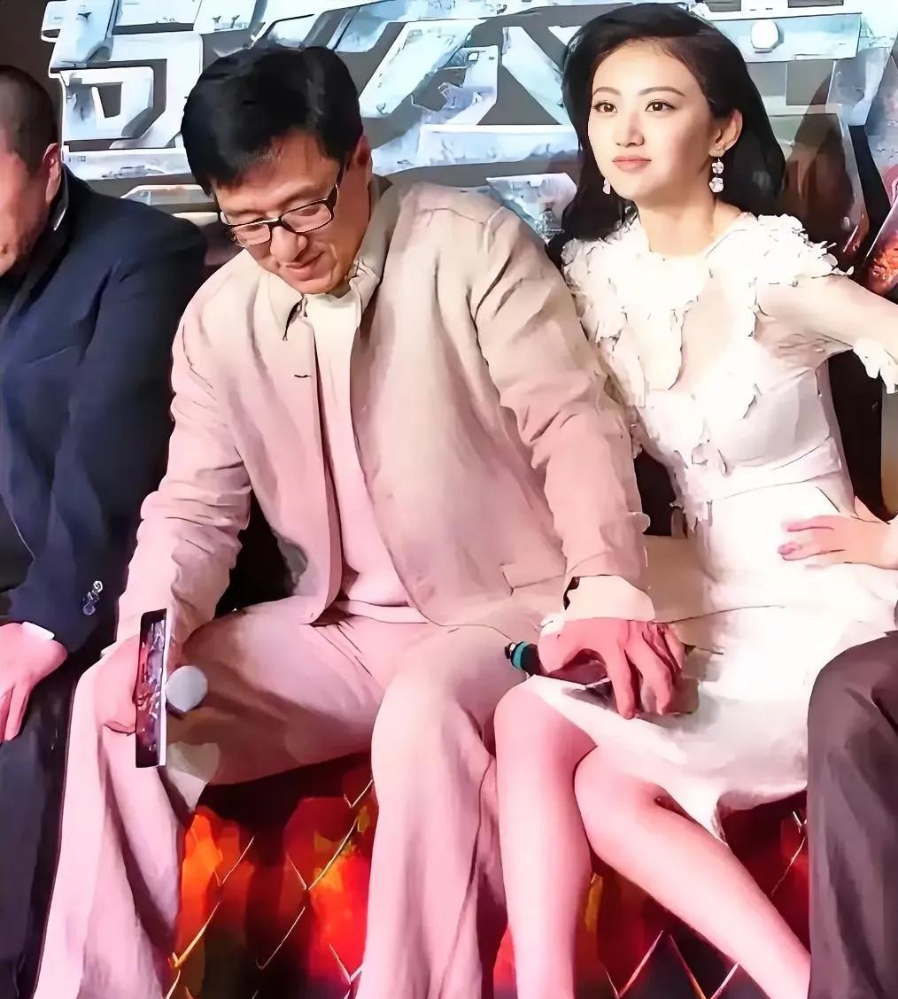 成龙的手不小心放在别人的腿上。旁边的美女，坐到成龙的身边，尽管博到了眼球，也不能