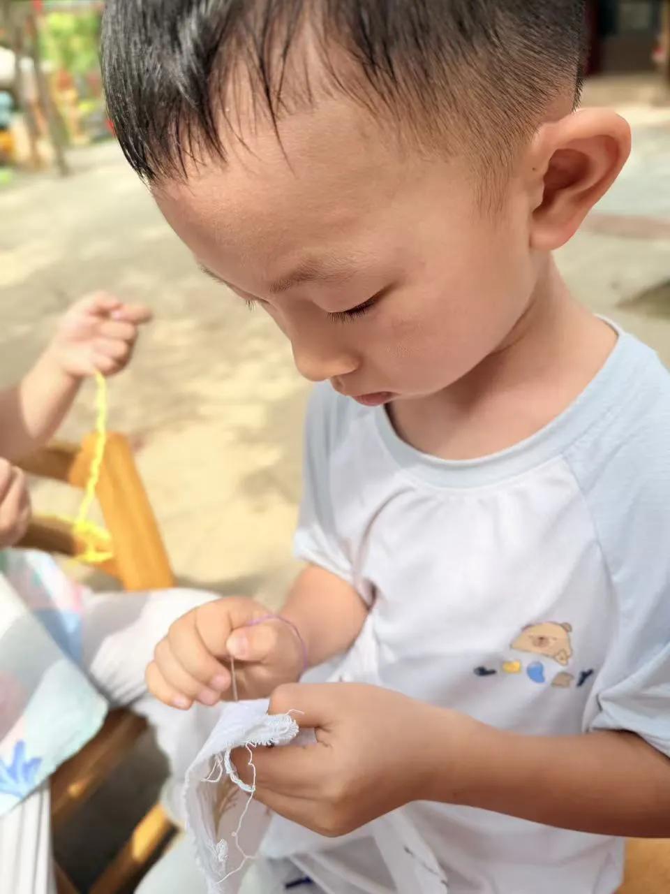 幼儿园的刺绣课有趣极了。小朋友们拿着钝头小针，小心翼翼穿彩色丝线，在棉布上绣小花
