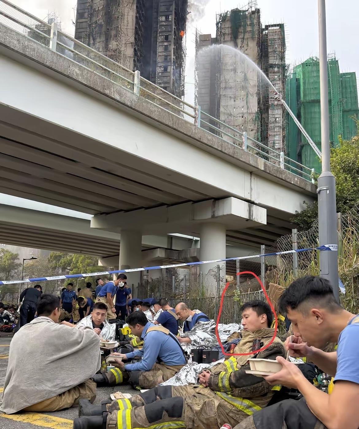 看到这张照片，真的让人瞬间心碎，起火的高楼还在冒黑烟，水枪的水还朝着火场浇