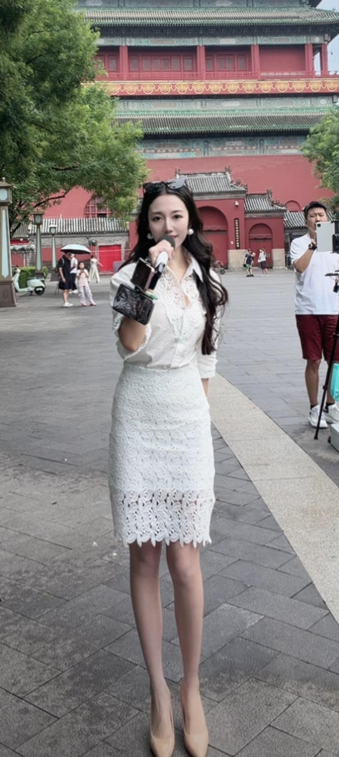 穿白裙子的美女在拍照。