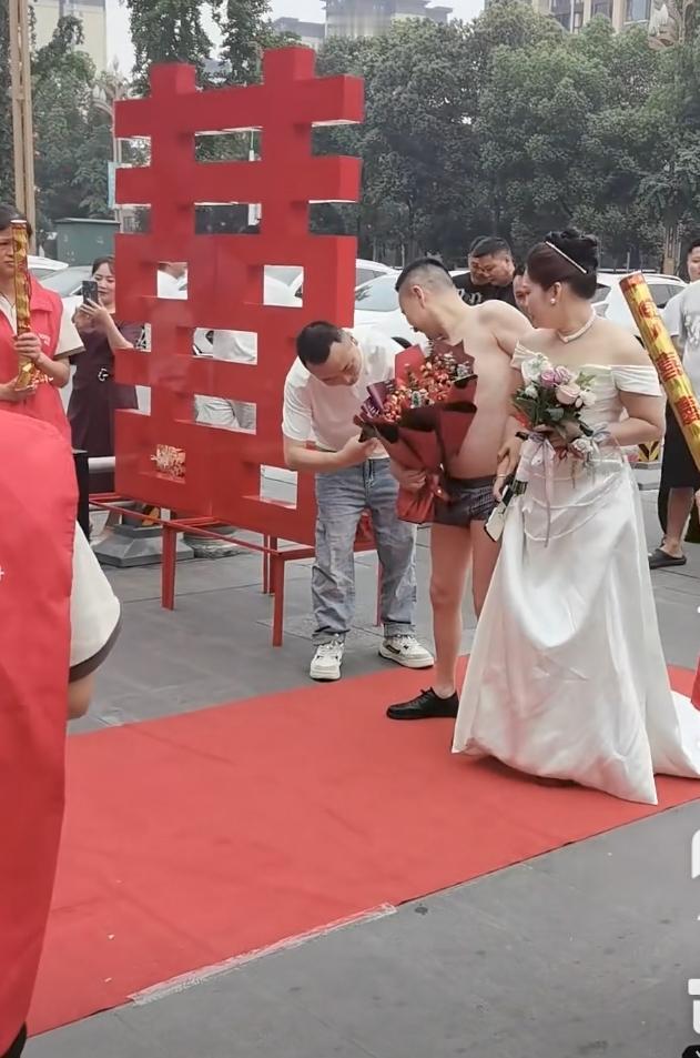 婚礼现场，新郎只穿裤衩走红地毯。不知道他是不是想表达被新娘一家榨干了，还是什么