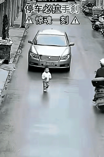 一辆轿车正往下溜，前面站着个小男孩！​旁边有人想冲上去，脚一软摔了。千钧一发，