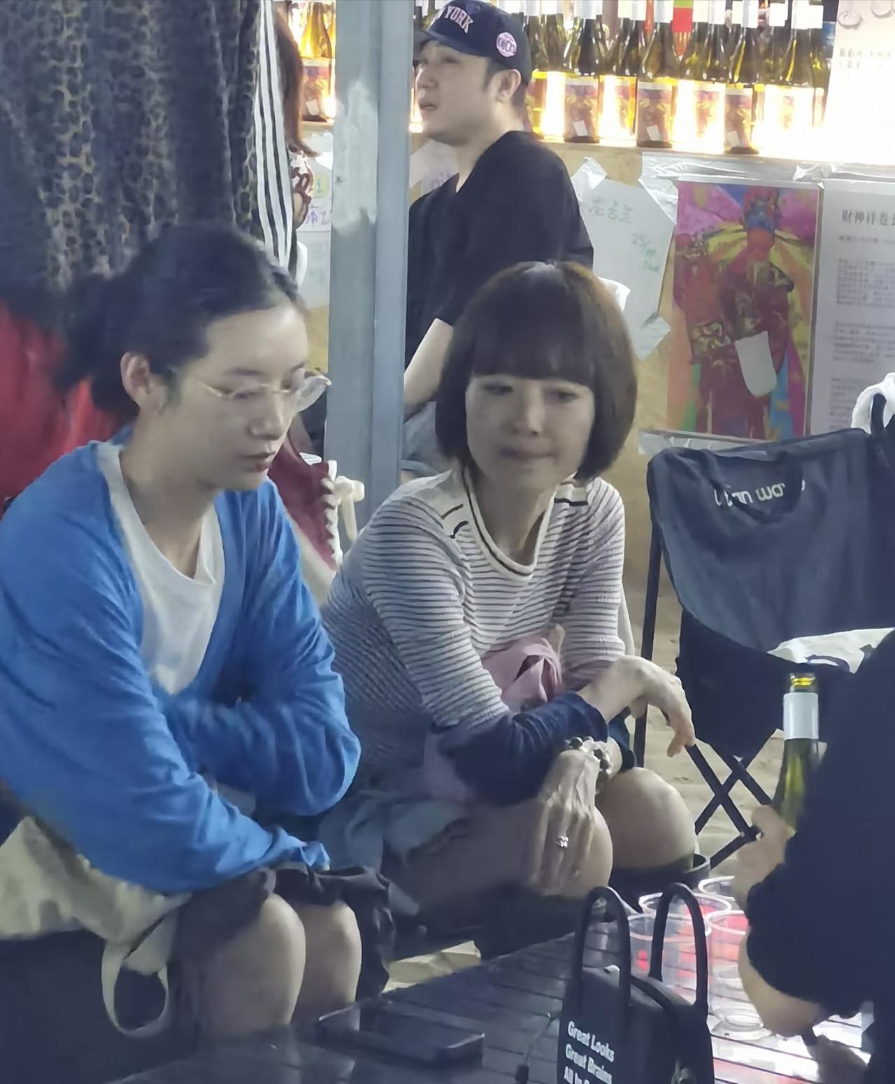鲁豫坐在阿那亚的一家小吃摊上，齐刘海短发，条纹T恤配长筒靴，时尚又减龄，