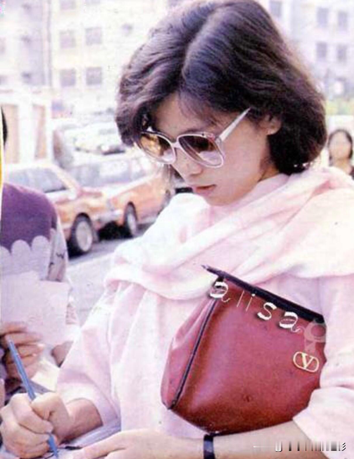 背着包包的翁美玲👜当年背的这只红棕挎包简直是80年代的“时尚硬通货”！包