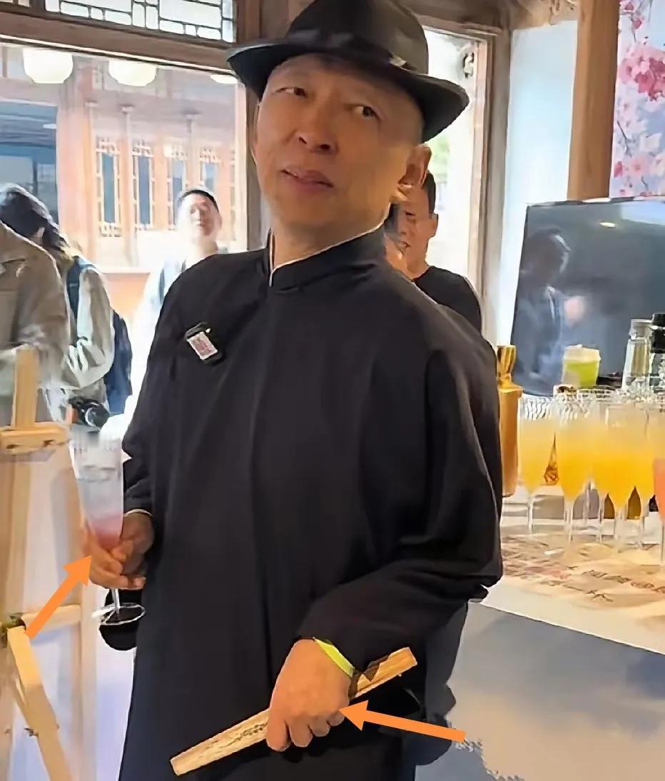 张朝阳左手折扇右手高杯美酒惬意品味。