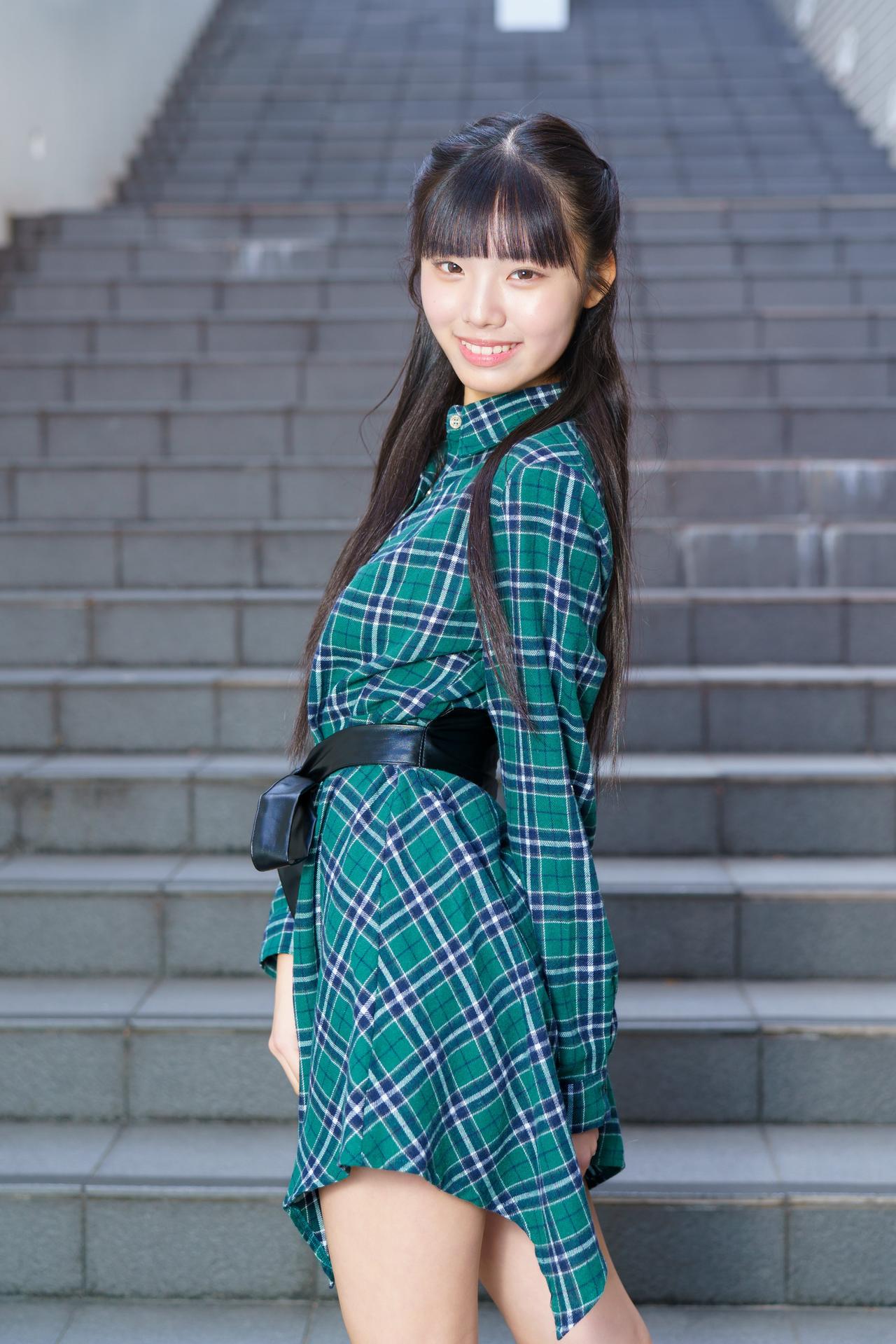 绿衣少女倚台阶，笑靥如花映晴空。