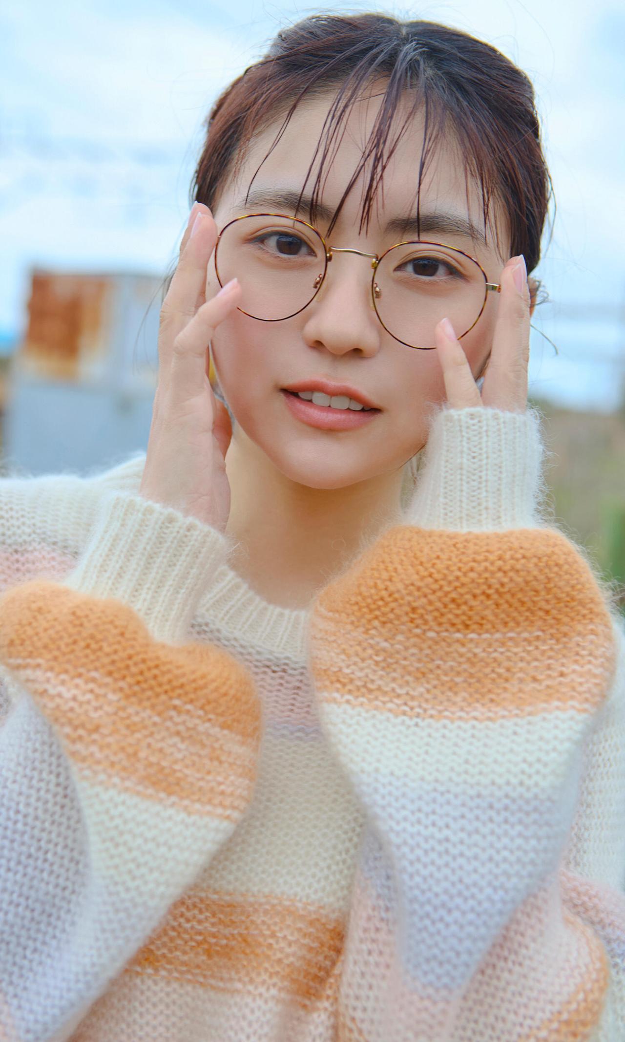 这姑娘戴眼镜，穿条纹毛衣，好可爱。