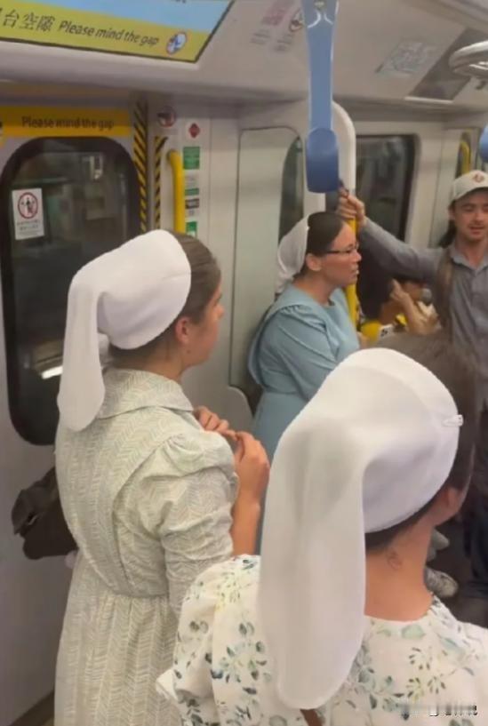5月7日，一群戴白头巾的外国人在香港地铁大声唱歌，热情好客的香港人安静欣赏，没有