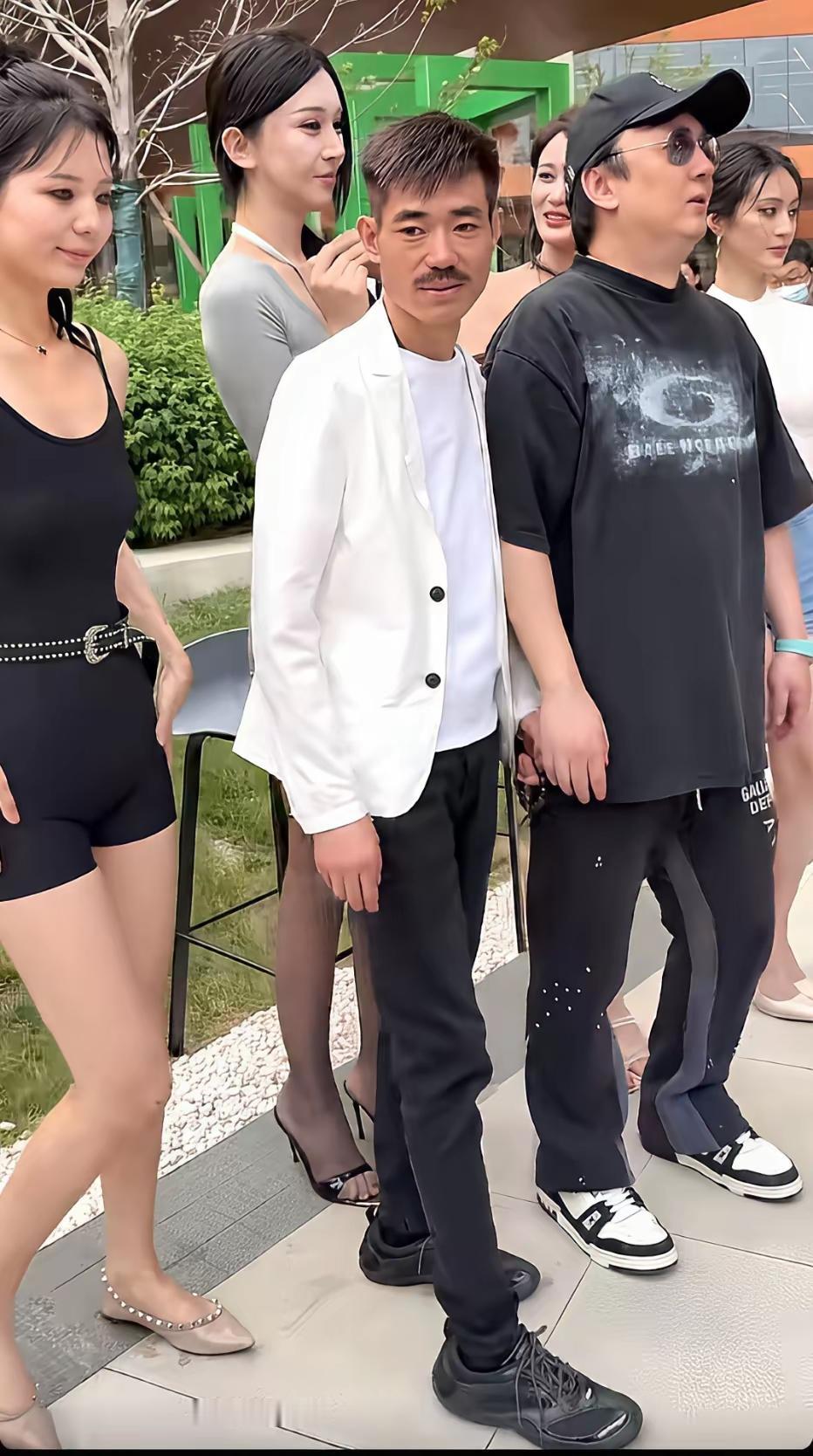 王思聪的模仿者与友人们，一群时尚美女尾随其后把玩世不恭的形象。穿白衣服的那个
