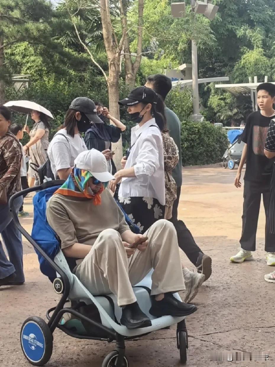 在北京环球影城，陈建斌伸手想牵蒋勤勤，却被她直接甩开，只好安静坐进小推车里等待。