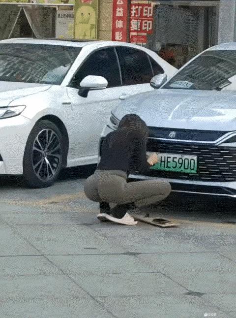 谁家的媳妇啊一点也不心疼！让一个美女安装车牌！不过这号码还真不错！一个女人家