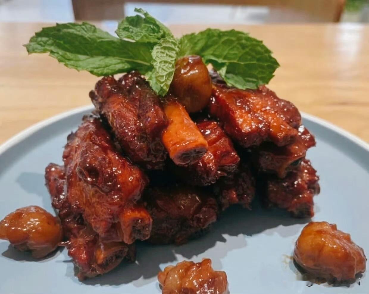 红亮的排骨裹着琥珀色的糖衣，配一颗蜜渍的莲子，甜香漫过舌尖；白瓷碗里盛着满当当