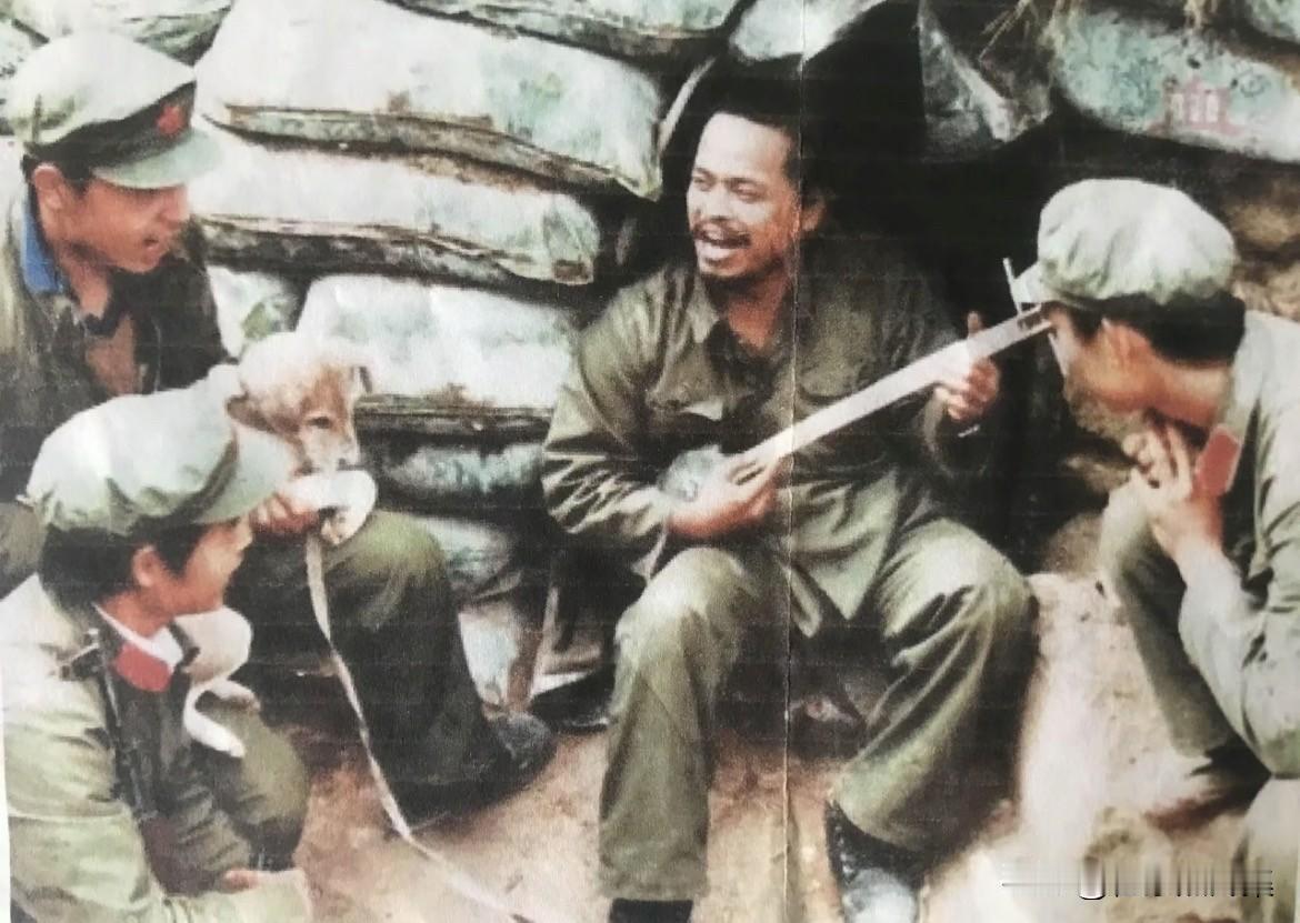 1984年12月老山前线，老班长何吉勇在猫耳洞弹吉它，和战友们唱歌，在艰苦条件下