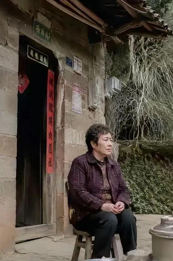 邹市明的母亲宋宋永慧坐在遵义老家的门前。（图一）邹父几年前去世后，邹母一直独居在