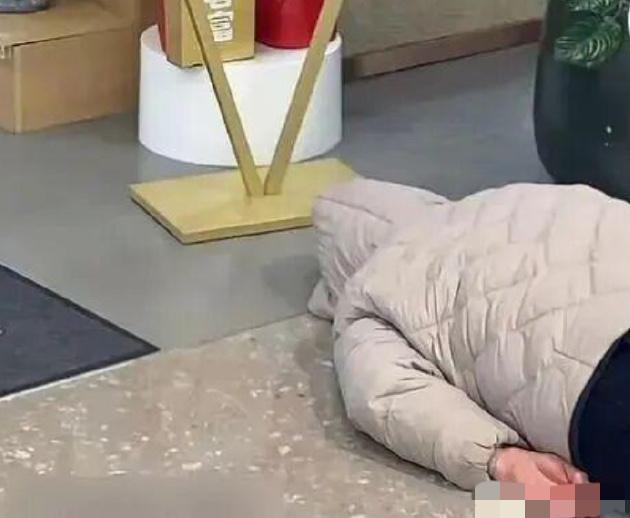 河南一女子躺人家店门口，头部用帽子盖住，整整赖了4天趴地不起。店家没辙，在女子旁