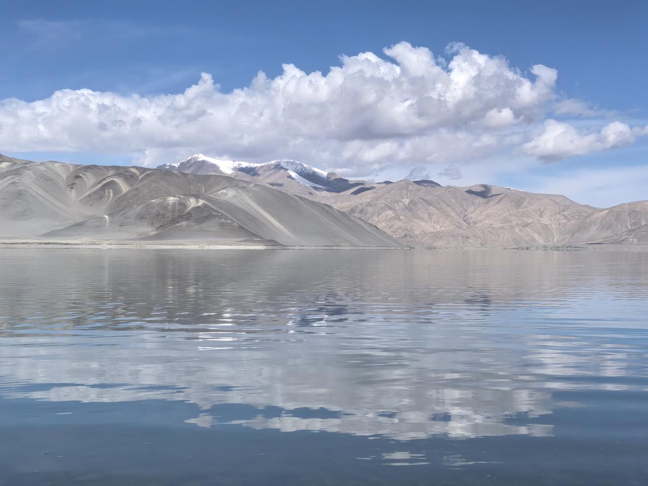 这是白沙湖的一张风景照片，白沙景点白沙铺岸，如雪似银，在阳光下泛着细碎的光。湖