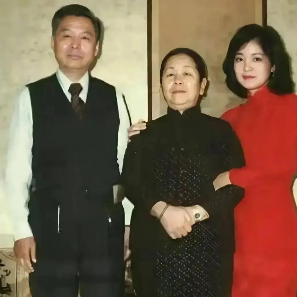 1975年，22岁的邓丽君和父母的合影，镜头中的邓丽君一身红衣，五官精致，如今他