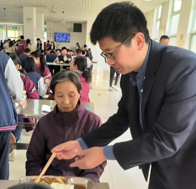 2023年，山东济南，一45岁的男教师带71岁患病的母亲一起上课。母亲每天扫地擦
