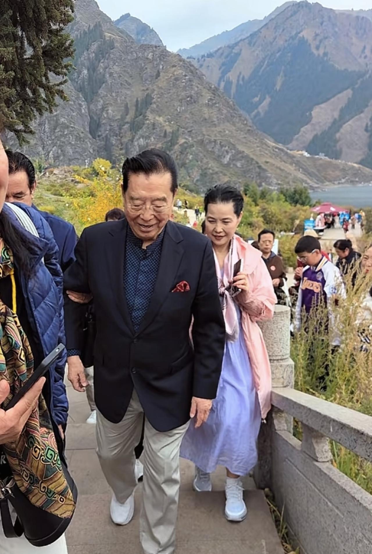 近日，李双江携妻子梦鸽到新疆游玩，夫妻俩现身天山池风景区的画面。86岁的李双江
