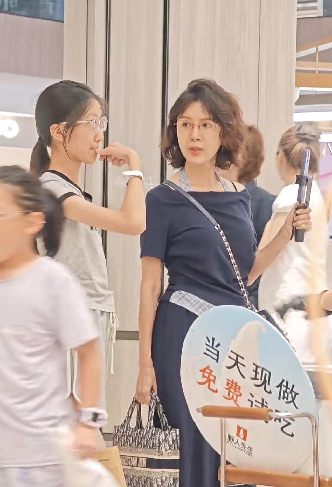 偶遇51岁金巧巧现身商场，她逛街排队时背挺得笔直，依旧很优雅，旁边13岁的大女儿