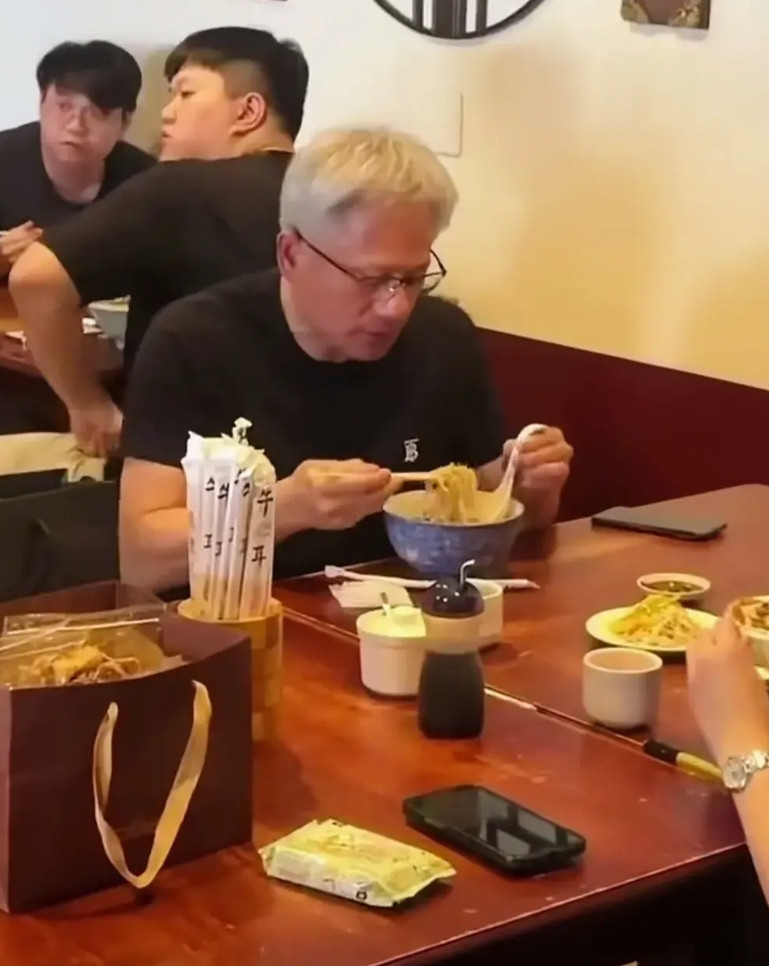 黄仁勋吃拉面还真有意思。一手拿筷子，一手吗勺子，先是用筷子把面条挑到勺子上，然后