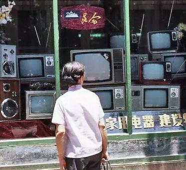 1983年，昆明，一名女子站在家用电器商店的橱窗前久久不愿离去。橱窗里面摆放着不