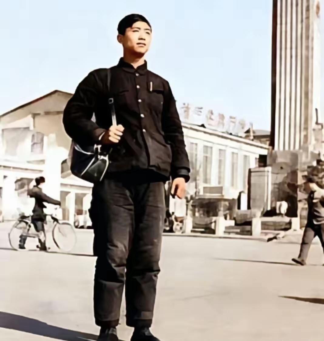一个穿黑色衣服的帅哥在街头走。1975年拍摄，这是谁你还记得吗？