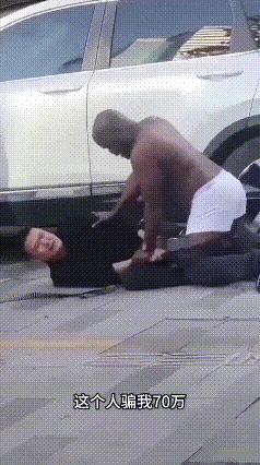 黑衣男子被黑人压在地上！男子拖住黑人，向路人寻求帮助“大哥，帮我抓一下，这个人