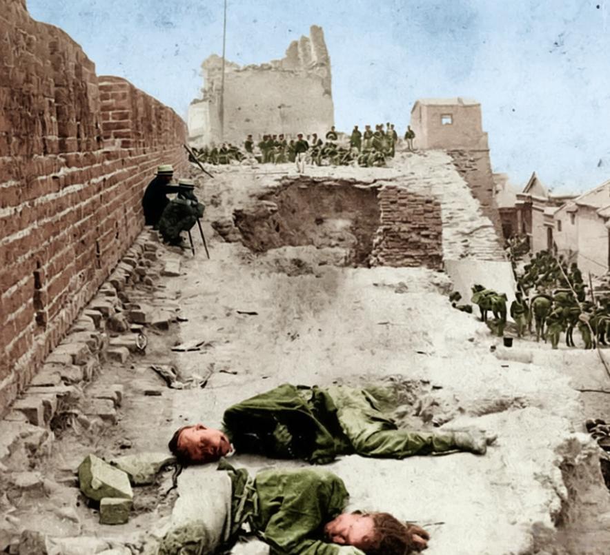 1900年，天津，青砖城墙被近代火炮轰开一道豁口，墙顶步道的尘沙里，清军士兵与义