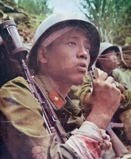 1987年4月20日，在老山战役，越军手持喷火器，喷向我方弹药库，一名嘴啃压缩