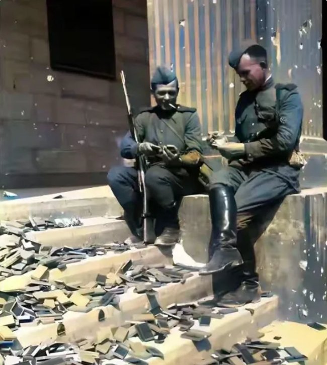 1945年，随着纳粹德国的覆灭，两名苏联士兵在满目疮痍的柏林街头席地而坐。在他们