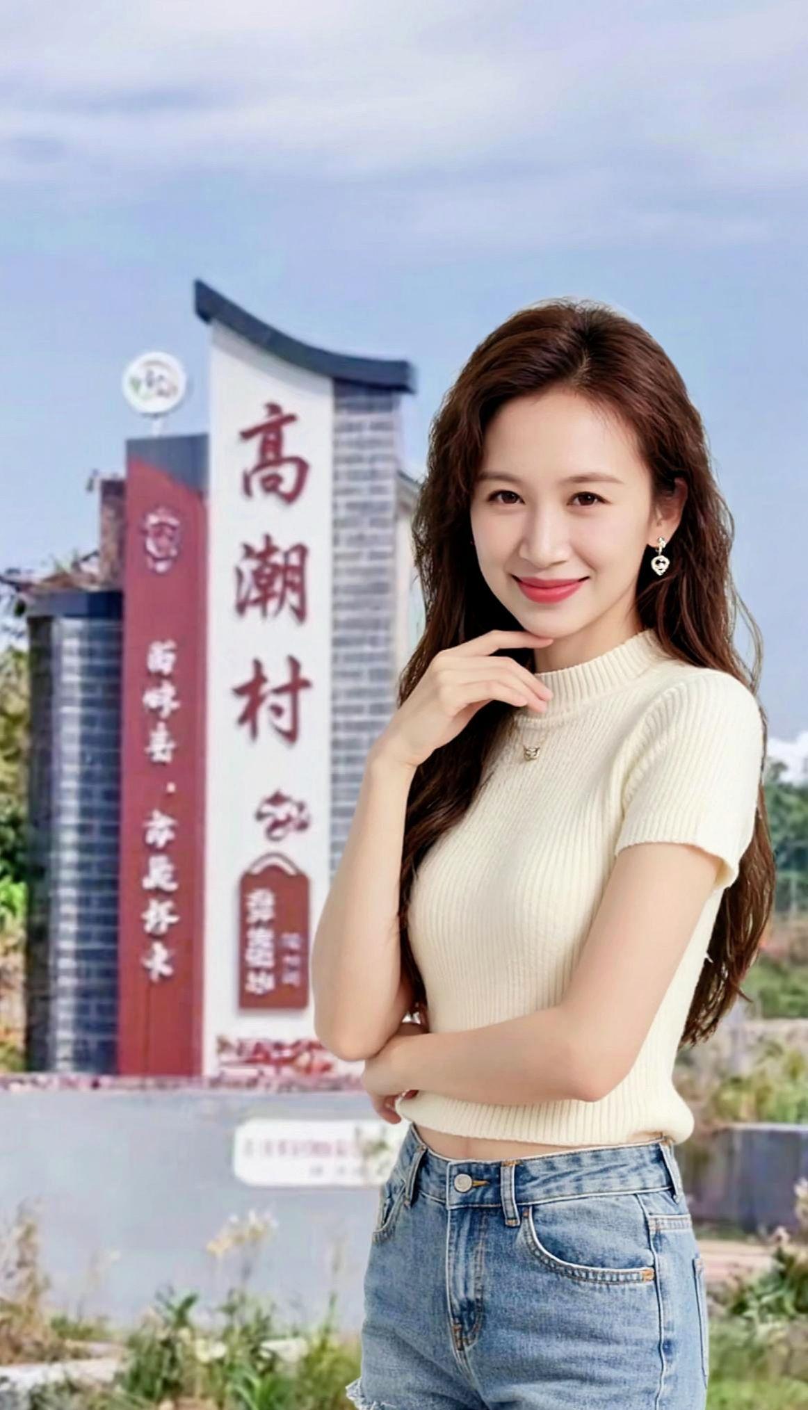 温柔的阳光洒在发梢，微风轻拂，仿佛时间都慢了下来。背景中的村庄牌楼，诉说着岁月的