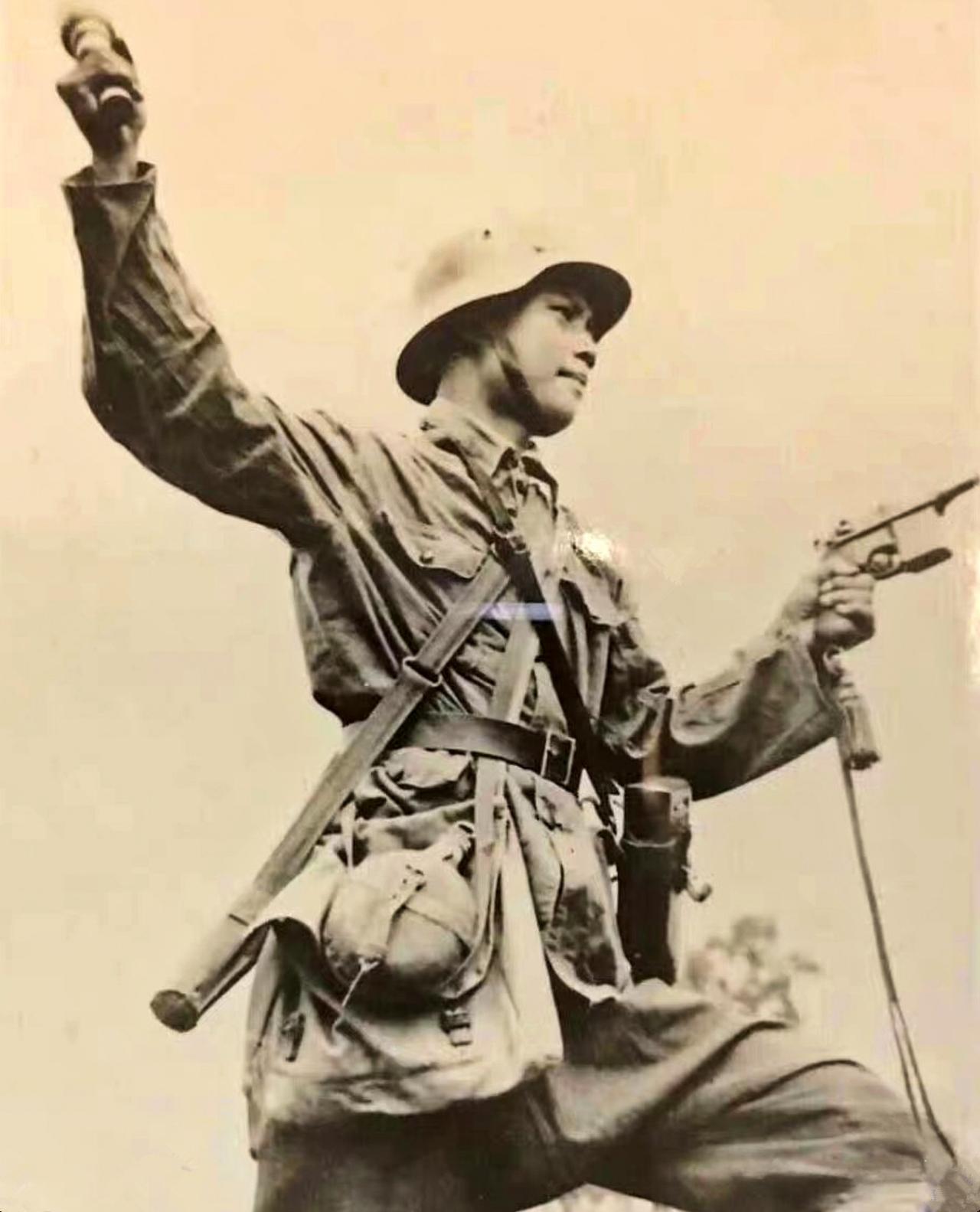 这是一张抗战时期一名中国士兵战斗时所拍摄的照片。只见他一手握着驳壳枪朝日军射击，