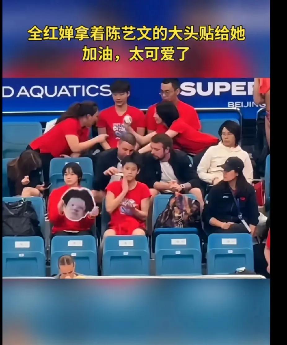 全红婵陈艺文神仙友谊在赛场观众席上，全红婵举着陈艺文的大头贴，卖力为好友加