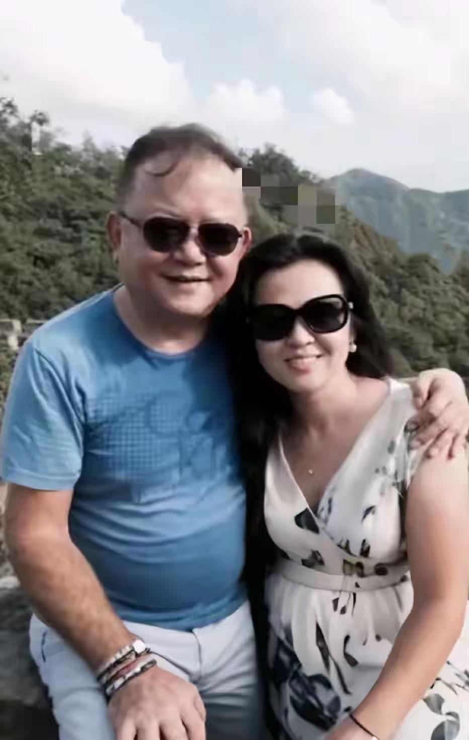 王刚与妻子郑艳东一同出游时的合影，镜头中两人亲密依偎，笑容幸福，王刚是国内知名全