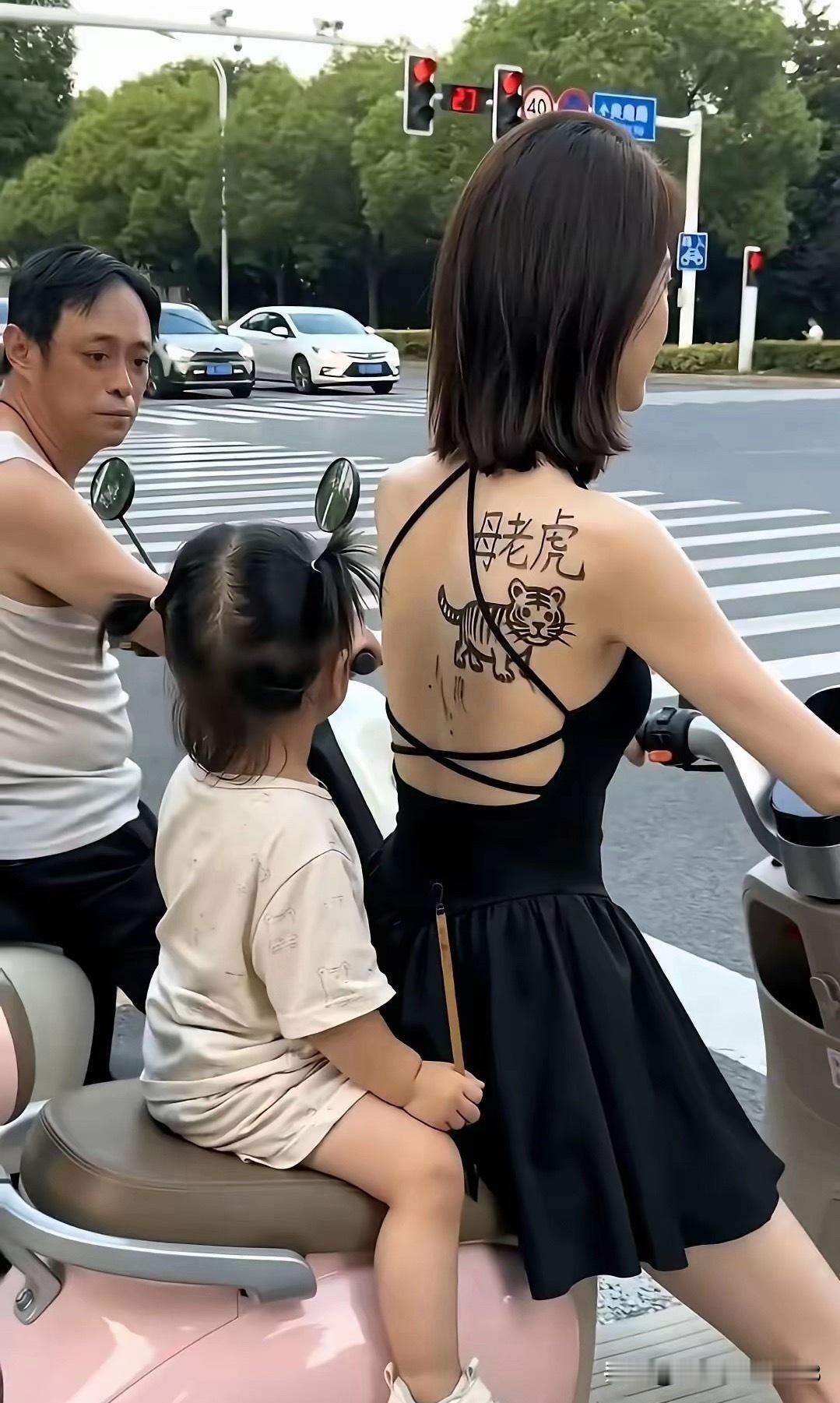 路上偶然看到这么一幕，一位女士骑着电动车带着孩子。穿着黑色连衣裙，最吸睛的