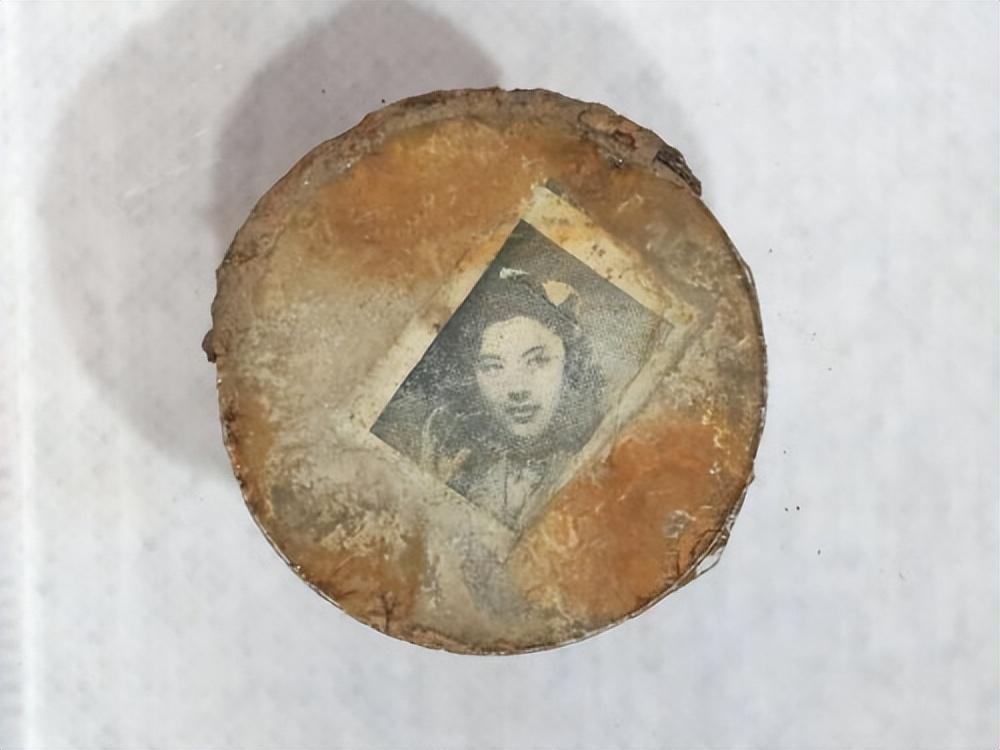 这面从506号志愿军烈士棺椁中清理出来的小铜镜，夹层里藏着一张泛黄的女子照片，背