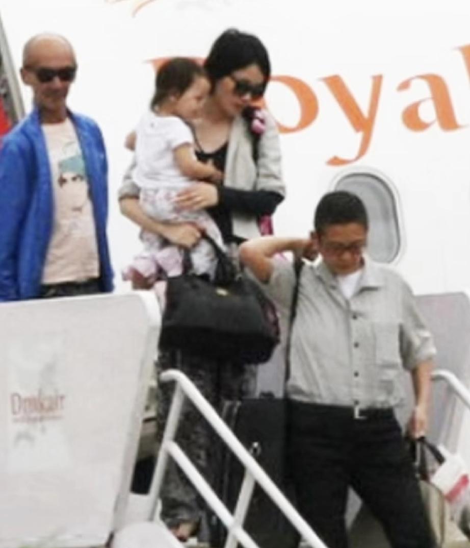 王菲抱着的李嫣才两岁，萌的像个布娃娃。小女孩的兔唇还在修复中。走下飞机的王菲