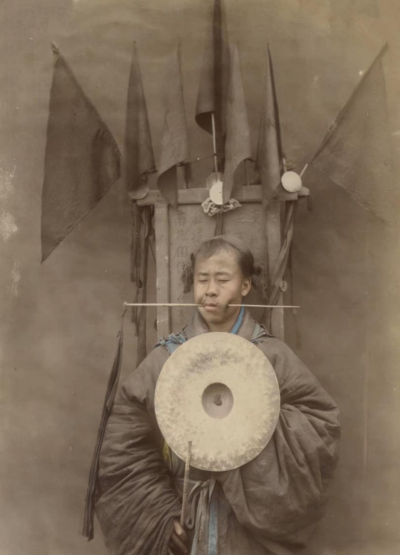 你敢信吗？这张1875年的晚清老照片里，一位道士正用一根钢针横穿自己的脸颊，背后