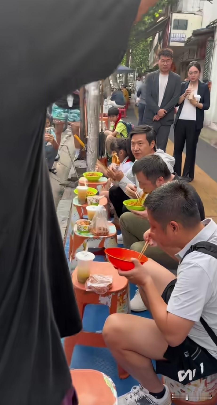 雷军在武汉店外吃干热面，引来一群人的围观，有拍照的，也有录制视频的，也有跟雷军对